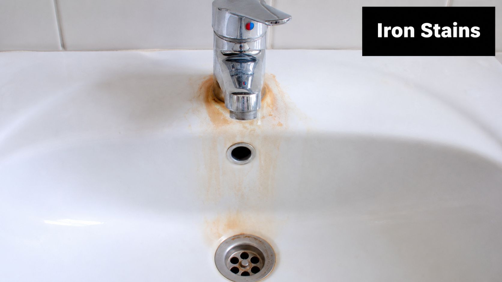 A white bathroom sink stained with brown iron residue around the faucet and the drain opening.